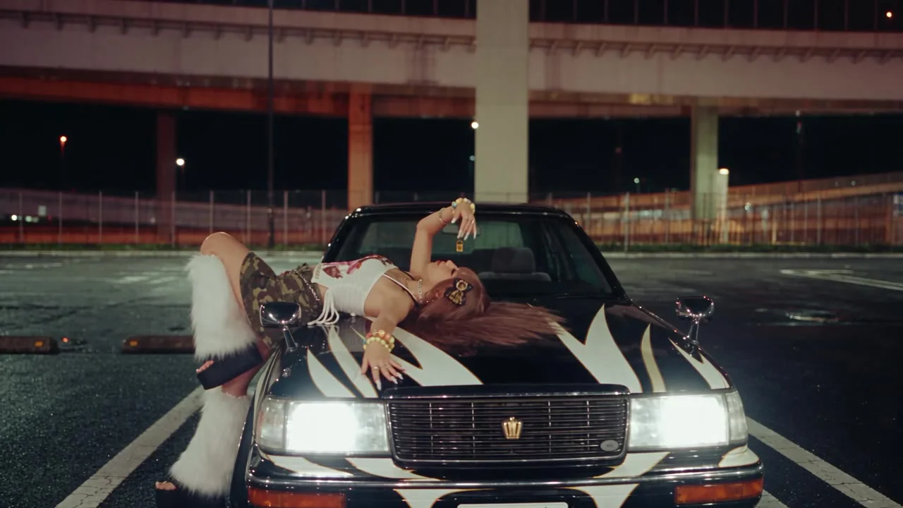 Blockout → final: lying across the bonnet under the expressway. The stand-in only marks where she is; the pose (head over the wing, one knee up) is written in the prompt.